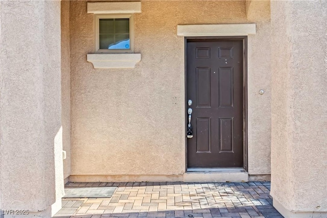 view of exterior entry with stucco siding