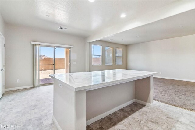 kitchen featuring a kitchen island and light stone countertops