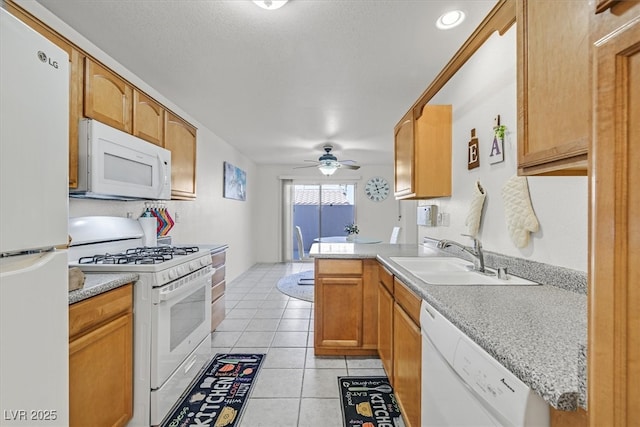 kitchen with ceiling fan, kitchen peninsula, sink, white appliances, and light tile patterned floors