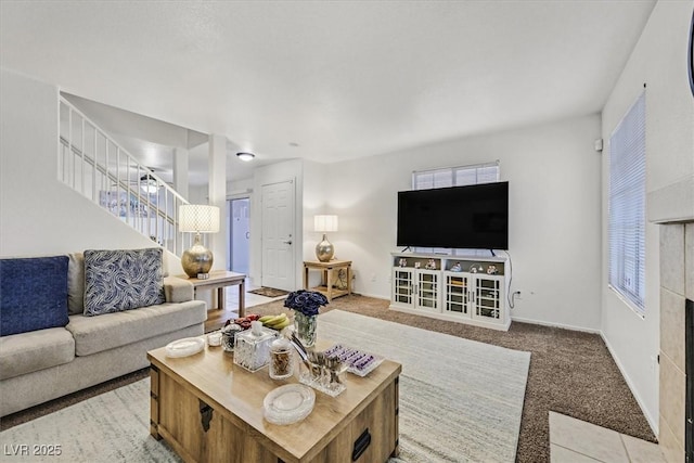 carpeted living room with a tiled fireplace