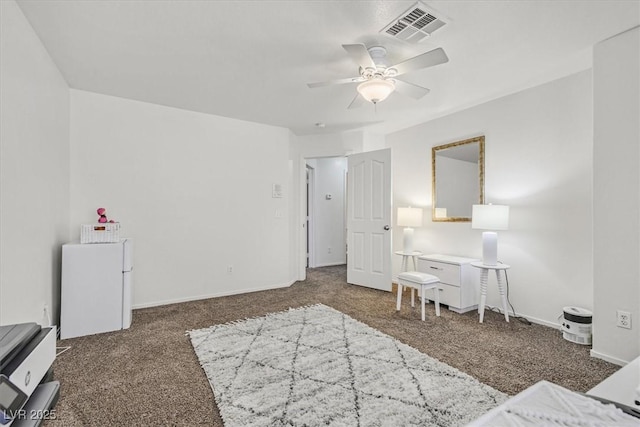 bedroom with ceiling fan, white refrigerator, and dark carpet