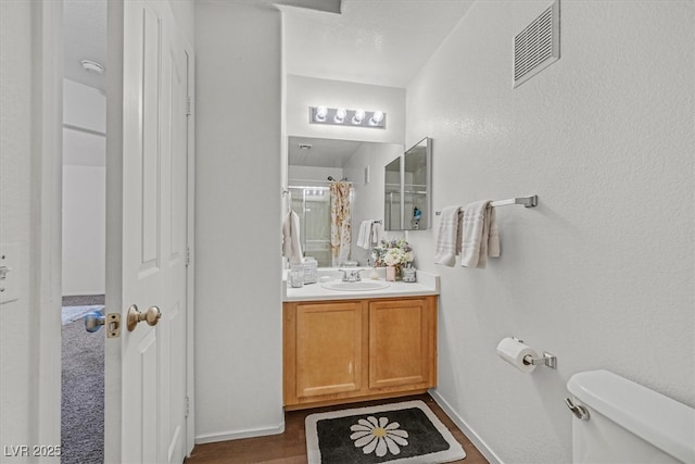 bathroom with curtained shower, toilet, and vanity