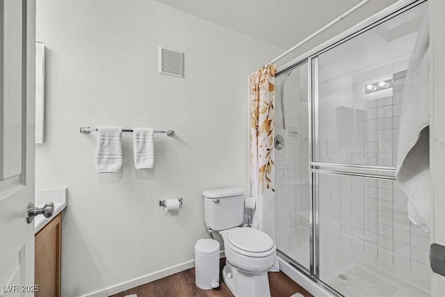 bathroom with toilet, a shower with door, and hardwood / wood-style floors