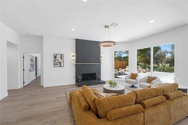 living room with light wood-type flooring and a fireplace