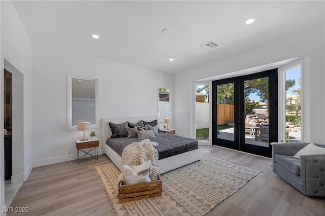 bedroom featuring french doors, light hardwood / wood-style flooring, and access to outside