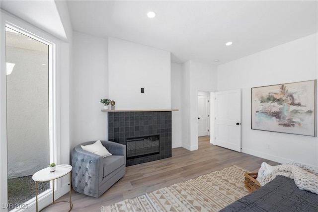 interior space featuring light wood-type flooring and a tile fireplace