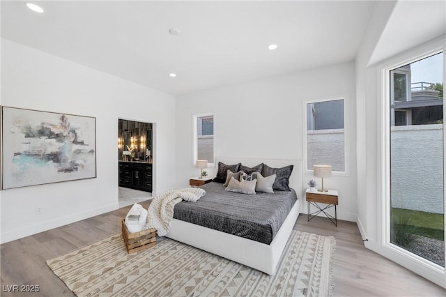 bedroom featuring light hardwood / wood-style floors, access to exterior, and connected bathroom