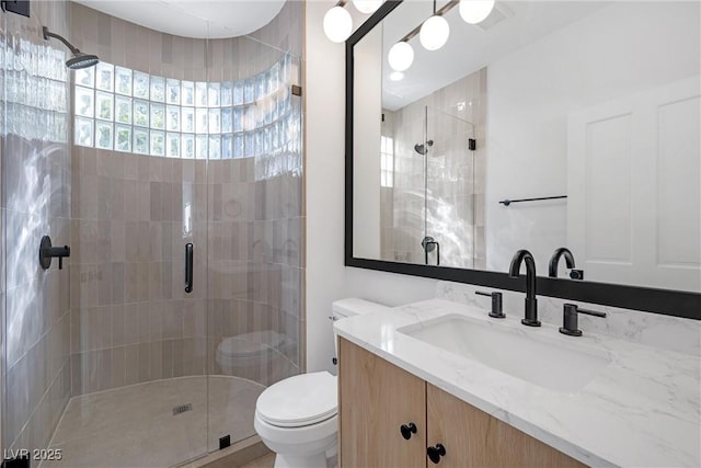 bathroom featuring toilet, vanity, and walk in shower