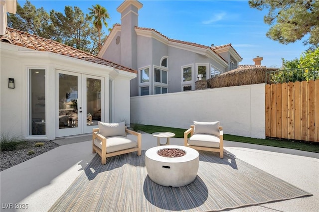 wooden deck featuring french doors, a patio area, and an outdoor fire pit