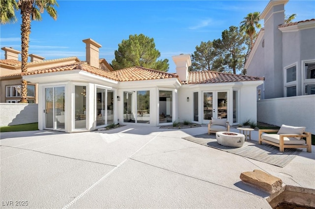 back of property featuring french doors, a fire pit, and a patio