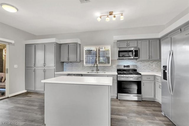 kitchen with tasteful backsplash, appliances with stainless steel finishes, sink, and a kitchen island