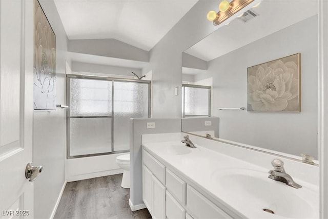 full bathroom featuring enclosed tub / shower combo, wood-type flooring, vanity, toilet, and vaulted ceiling