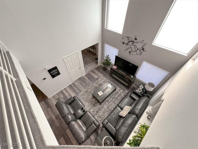 unfurnished living room featuring a towering ceiling and hardwood / wood-style floors