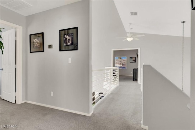 hall with light carpet and vaulted ceiling