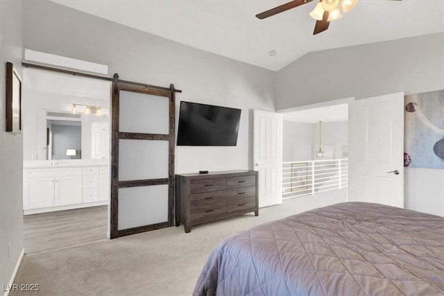 carpeted bedroom with ceiling fan, ensuite bathroom, lofted ceiling, and a barn door