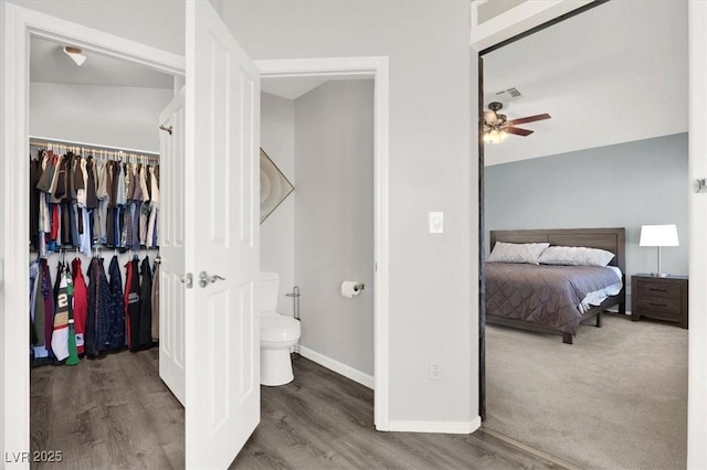 bathroom featuring toilet, ceiling fan, and wood-type flooring