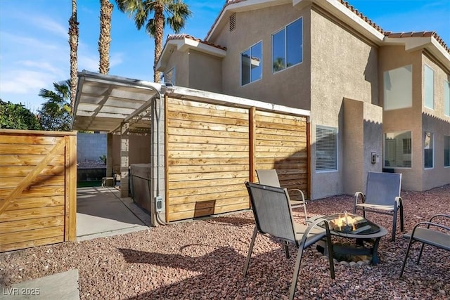 back of property featuring an outdoor fire pit and a patio area