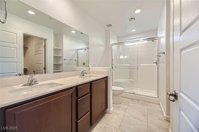 bathroom featuring toilet, tile patterned floors, walk in shower, and vanity