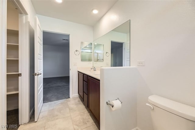 bathroom with toilet, tile patterned flooring, and vanity