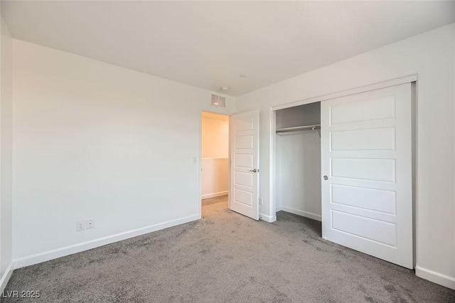 unfurnished bedroom with light carpet and a closet