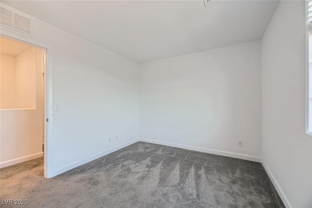 unfurnished room featuring dark carpet