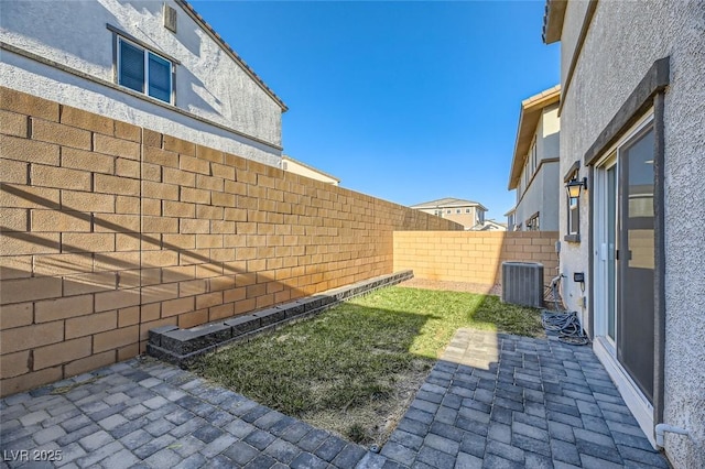 view of yard with central air condition unit and a patio area