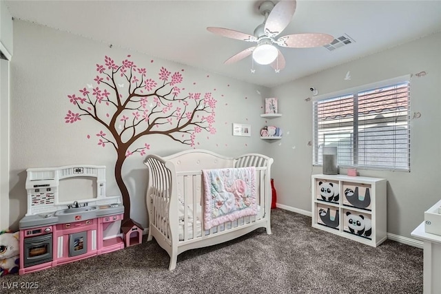 bedroom with ceiling fan, carpet, and a crib