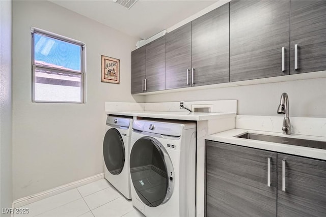 laundry room with washer and dryer, cabinets, sink, and light tile patterned flooring