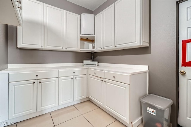 clothes washing area featuring light tile patterned floors