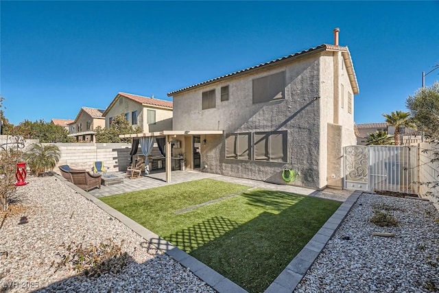 rear view of house with a lawn and a patio area