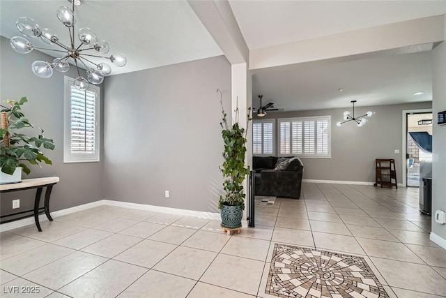 interior space featuring light tile patterned floors and ceiling fan with notable chandelier