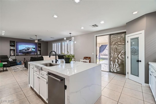 kitchen with stainless steel dishwasher, sink, an island with sink, white cabinets, and ceiling fan with notable chandelier