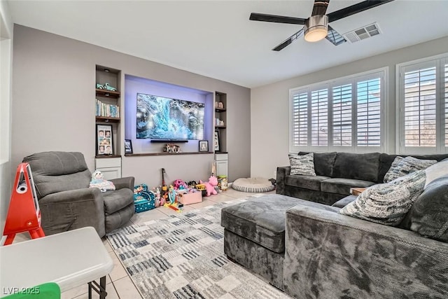 living room featuring ceiling fan, plenty of natural light, and light tile patterned floors