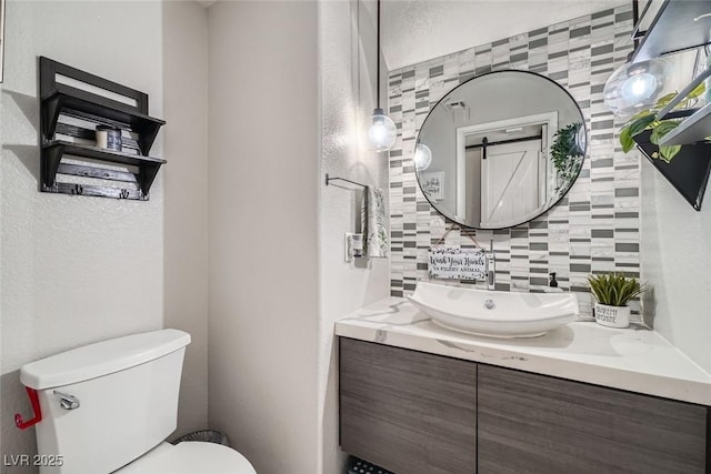 bathroom with toilet, tasteful backsplash, and vanity