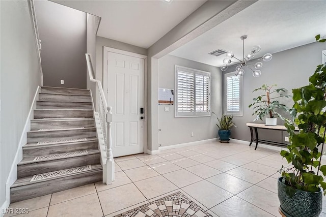 entryway with light tile patterned floors and a notable chandelier