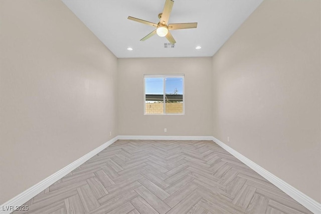 empty room with ceiling fan and light parquet flooring