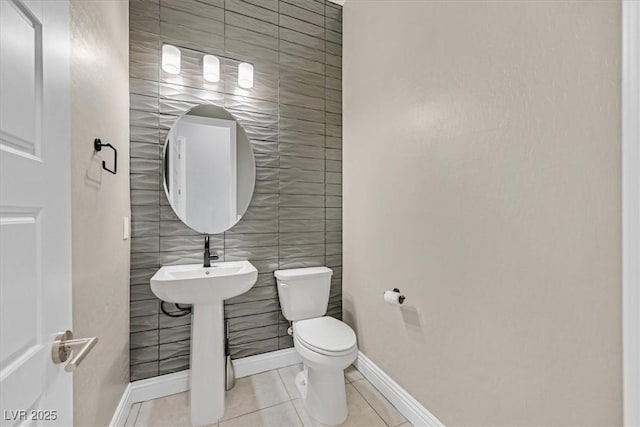 bathroom featuring tile walls, tile patterned floors, and toilet