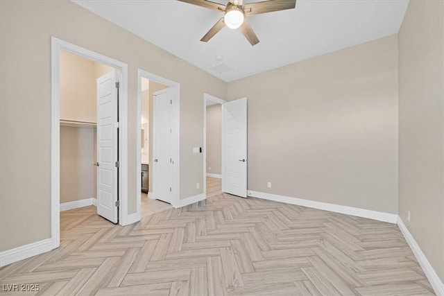 unfurnished bedroom with ceiling fan, light parquet flooring, a closet, and a walk in closet