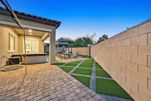 exterior space featuring a gazebo, a hot tub, and a patio