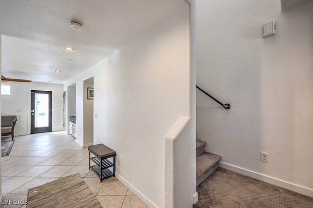 stairs featuring ceiling fan and tile patterned floors