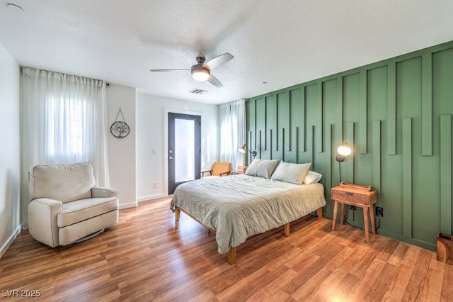 bedroom featuring ceiling fan, a textured ceiling, and hardwood / wood-style floors