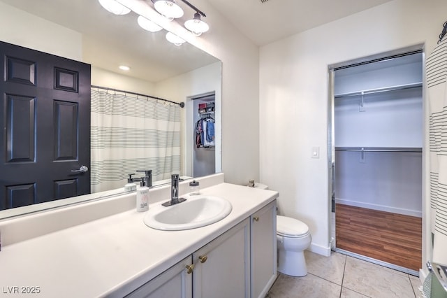 bathroom with toilet, tile patterned flooring, and vanity