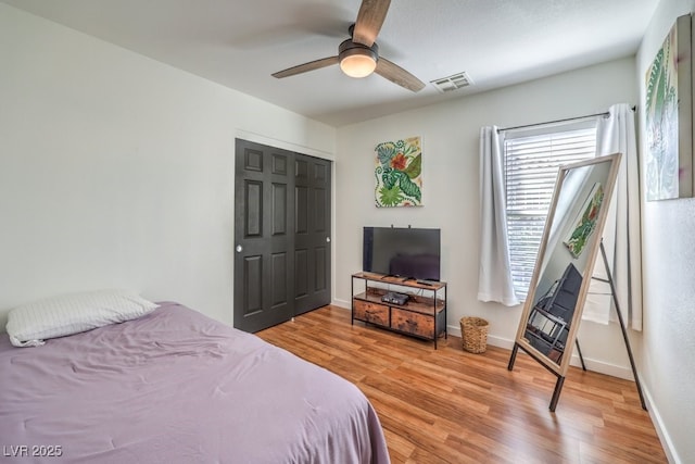 bedroom with ceiling fan, light hardwood / wood-style floors, and a closet