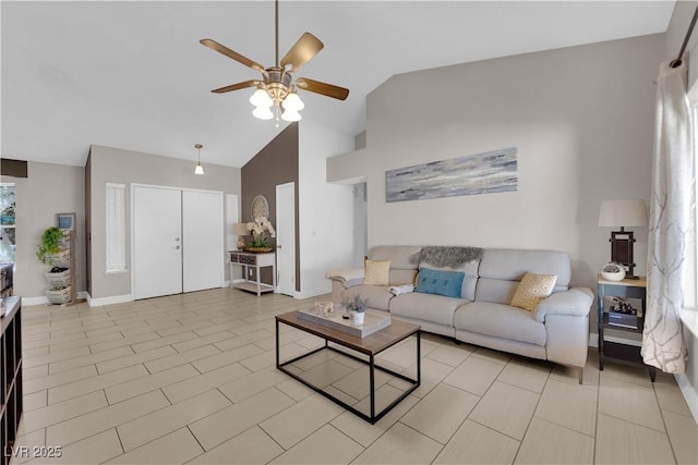 living area with high vaulted ceiling, ceiling fan, and baseboards