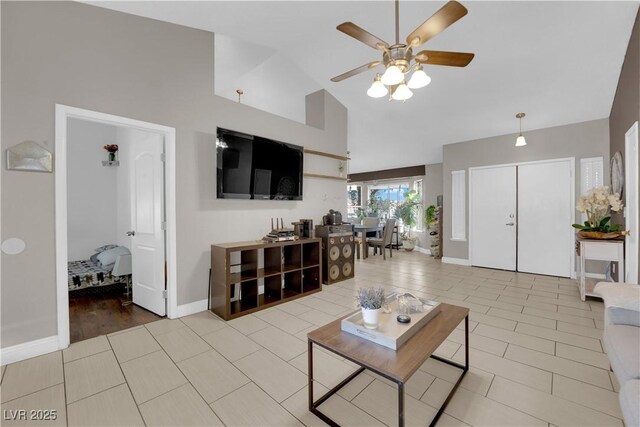 living room with ceiling fan, light tile patterned flooring, and high vaulted ceiling