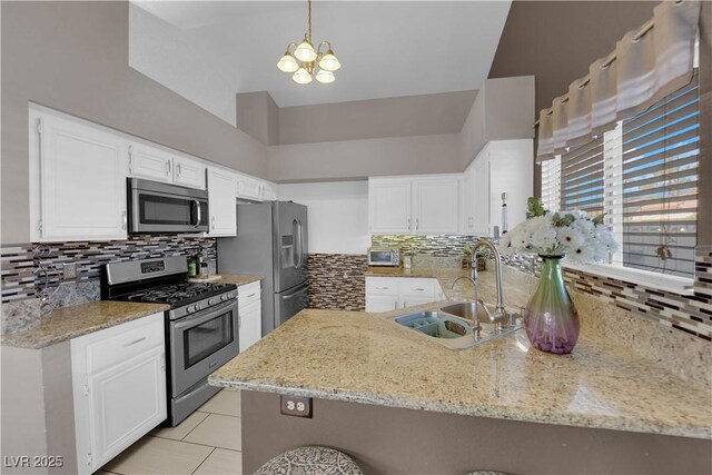 kitchen with kitchen peninsula, sink, stainless steel appliances, and white cabinetry