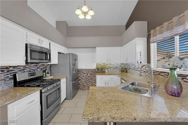 kitchen with a notable chandelier, sink, white cabinetry, stainless steel appliances, and light tile patterned floors