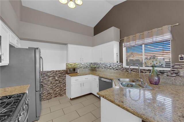 kitchen with gas stove, light stone countertops, stainless steel dishwasher, white cabinets, and sink