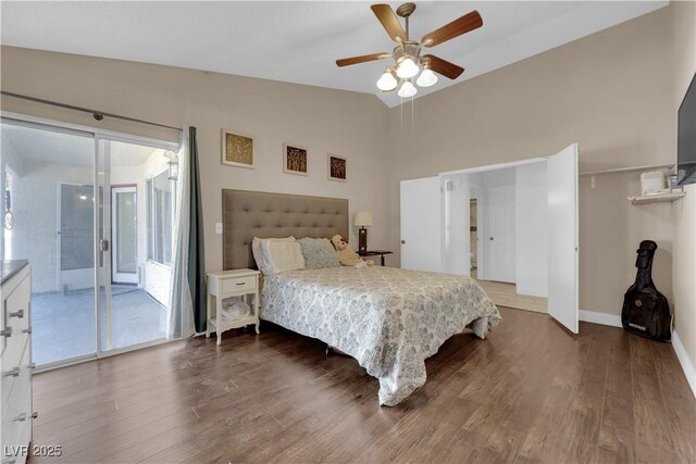 bedroom with ceiling fan, access to exterior, dark hardwood / wood-style floors, and vaulted ceiling