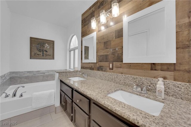 bathroom featuring a bathtub, vanity, and tile patterned flooring